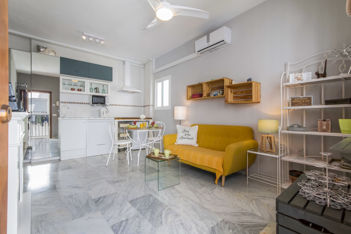 Salón con sofá amarillo y cocina